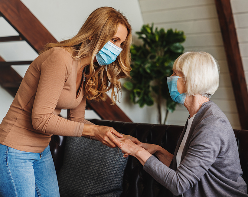 Caregiver in a medical mask with a senior woman