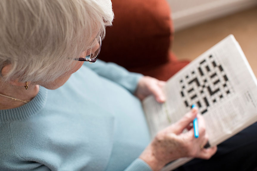 elderly resident doing a crossword puzzle